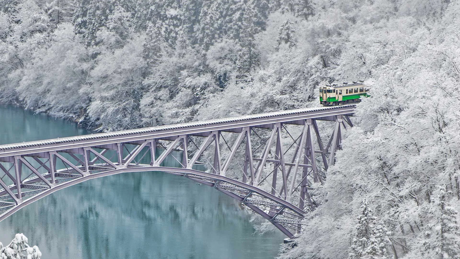 Train crossing the Tadami River near the village of Mishima in Japan